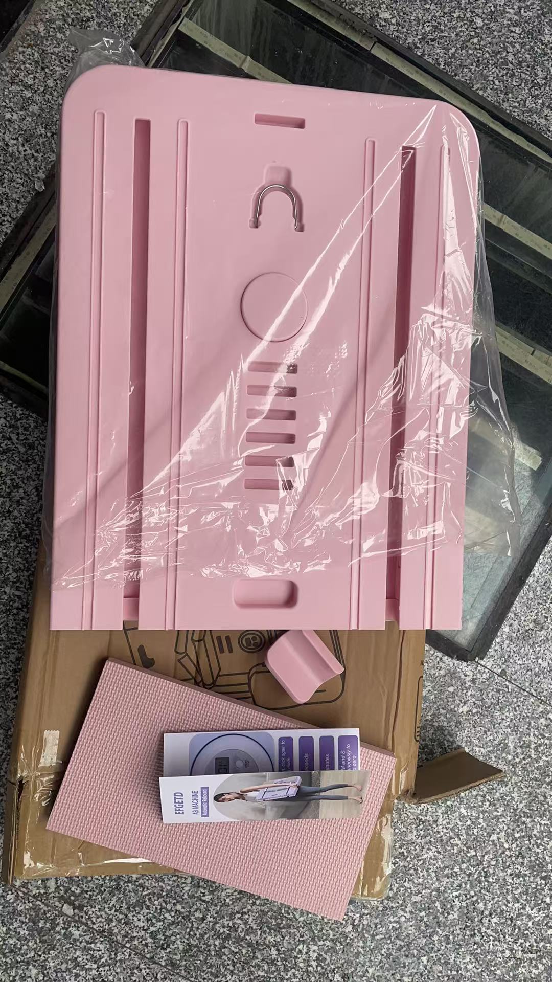 Alligné pink Pilates reformer board in packaging, showing its compact, foldable design for home workouts and easy storage.